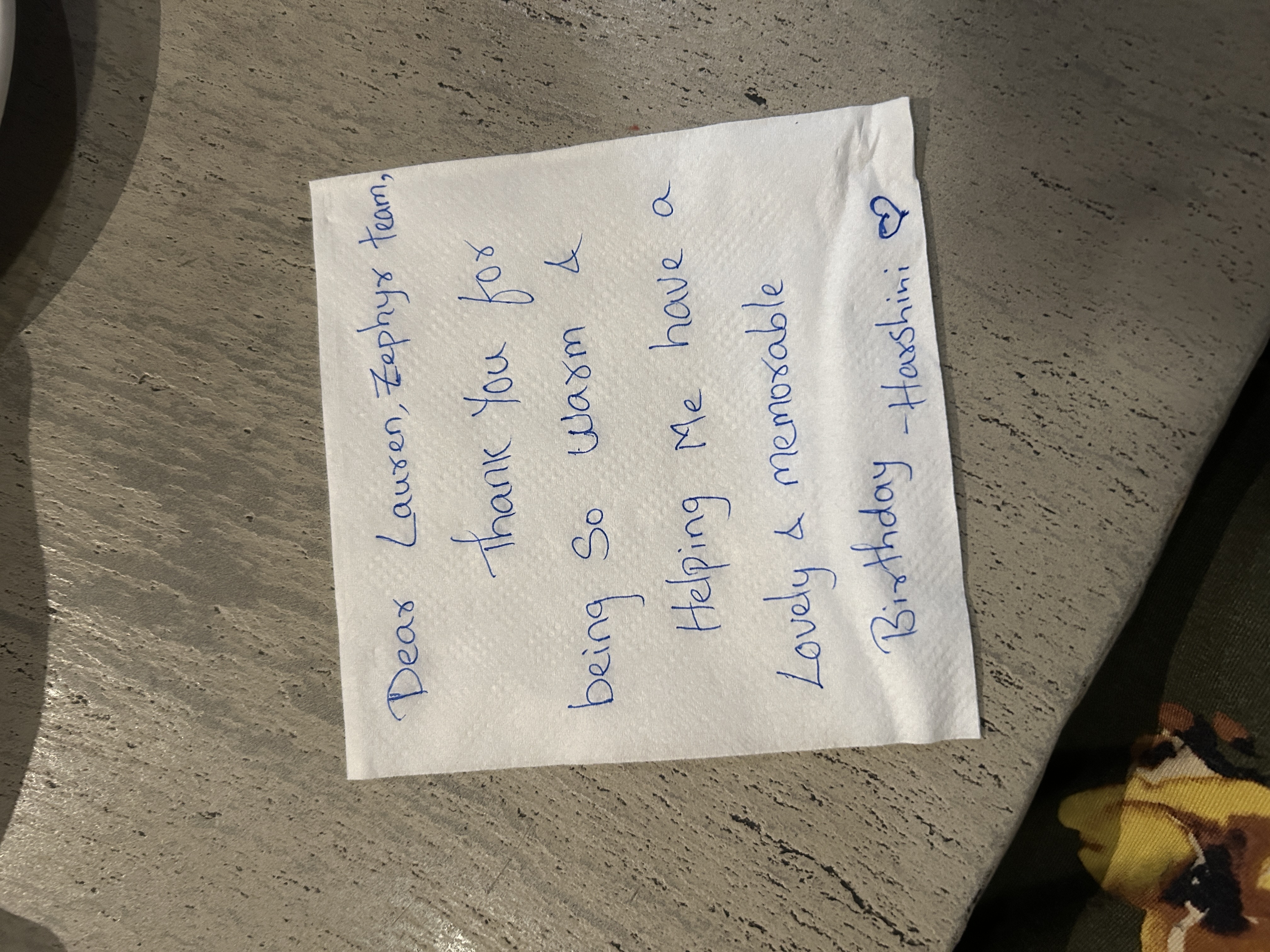 A handwritten thank-you note to Lauren and the Zephyr team lies on a restaurant table.
